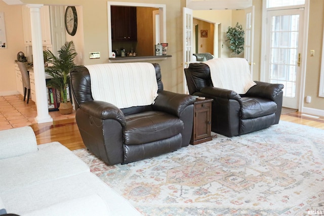 1112 W Cedar Hills Dr, Dunlap, IL 61525 - living area with decorative columns, plenty of natural light, and light wood-type flooring