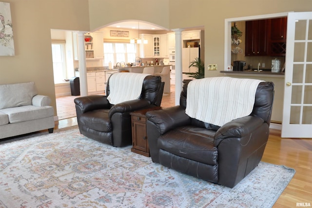 1112 W Cedar Hills Dr, Dunlap, IL 61525 - living area featuring decorative columns, arched walkways, and light wood finished floors