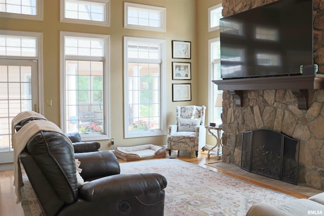 1112 W Cedar Hills Dr, Dunlap, IL 61525 - living area featuring healthy amount of natural light, wood finished floors, a stone fireplace, and a towering ceiling