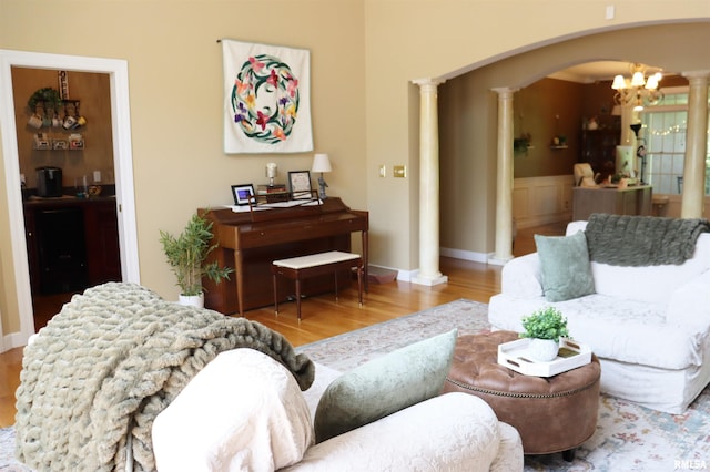 1112 W Cedar Hills Dr, Dunlap, IL 61525 - living area featuring ornate columns, arched walkways, wood finished floors, and a chandelier