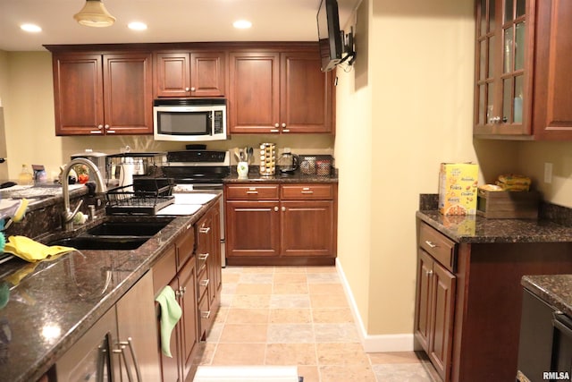 1112 W Cedar Hills Dr, Dunlap, IL 61525 - kitchen featuring stainless steel appliances, a sink, recessed lighting, dark stone counters, and baseboards