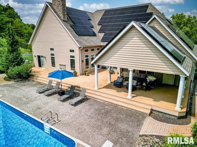 1112 W Cedar Hills Dr, Dunlap, IL 61525 - rear view of property with a wooden deck, an outdoor pool, roof with shingles, and a chimney