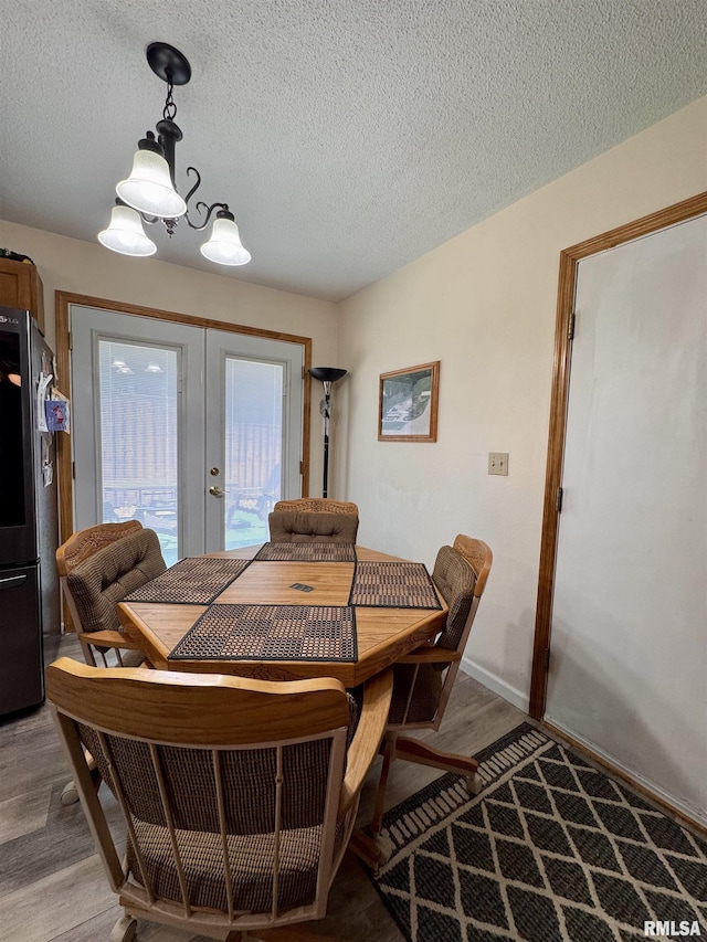 1612 Joyce Ln, Macomb, IL 61455 - dining space with french doors, light wood-type flooring, a textured ceiling, and baseboards