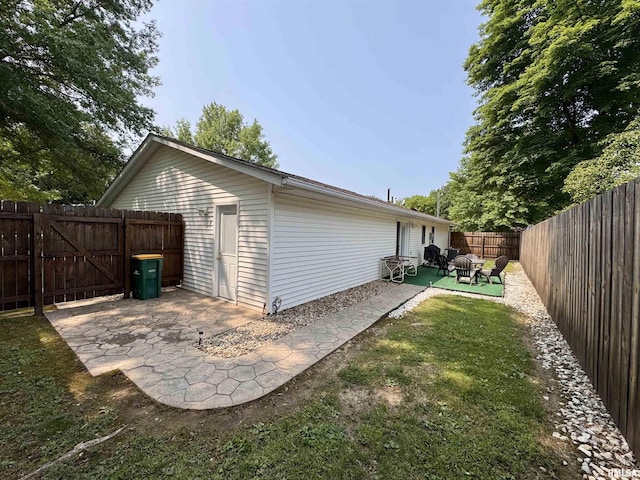 1612 Joyce Ln, Macomb, IL 61455 - view of side of property with a patio, a fenced backyard, and a gate