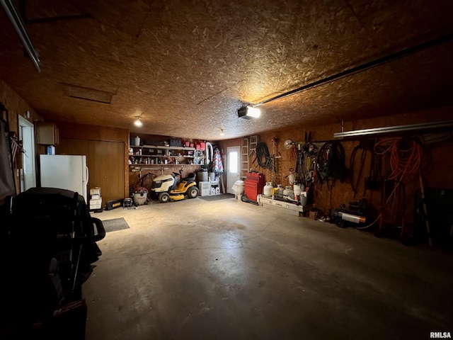1612 Joyce Ln, Macomb, IL 61455 - garage with a garage door opener, a workshop area, and freestanding refrigerator