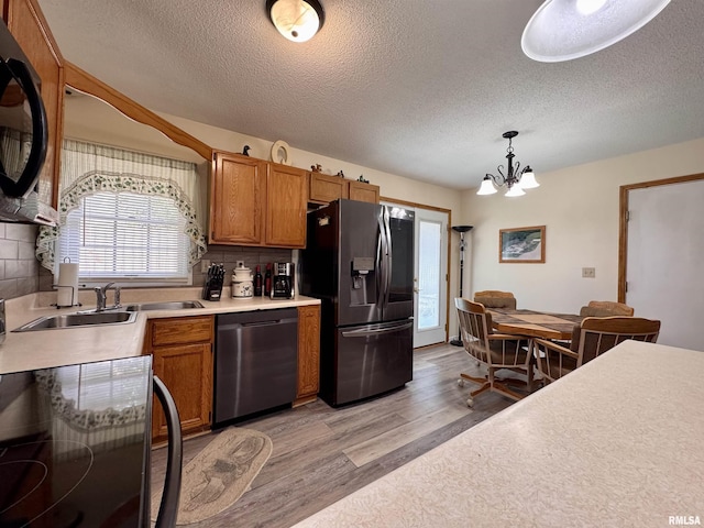 1612 Joyce Ln, Macomb, IL 61455 - kitchen with stainless steel refrigerator with ice dispenser, dishwasher, light wood-type flooring, light countertops, and a chandelier