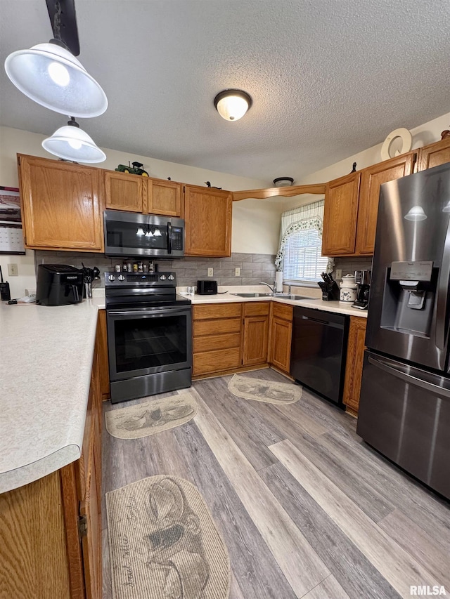 1612 Joyce Ln, Macomb, IL 61455 - kitchen with black appliances, brown cabinets, light countertops, and a textured ceiling