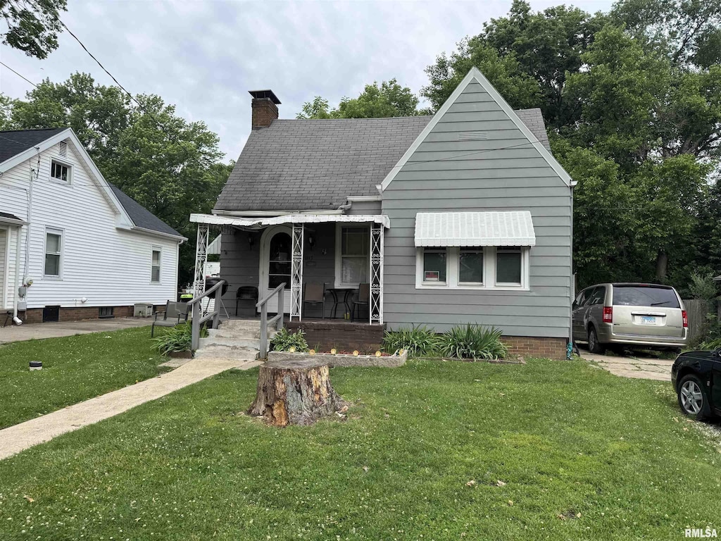 1917 N Broadway St, Peoria, IL 61604 - bungalow-style house featuring a porch, a chimney, a front yard, and roof with shingles