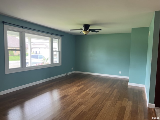 1302 Maple Ave, Macomb, IL 61455 - unfurnished room with dark wood-type flooring, ceiling fan, and baseboards