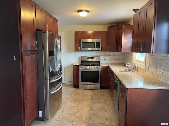 1302 Maple Ave, Macomb, IL 61455 - kitchen featuring stainless steel appliances, a sink, tasteful backsplash, light tile patterned floors, and light stone countertops