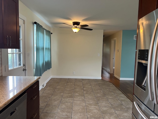 1302 Maple Ave, Macomb, IL 61455 - kitchen featuring stainless steel appliances, ceiling fan, tile patterned floors, light stone counters, and baseboards