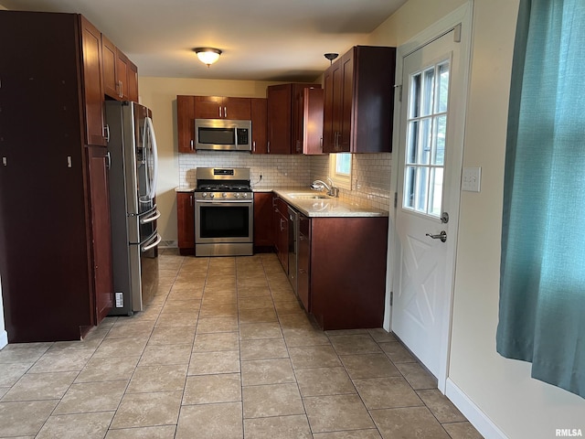 1302 Maple Ave, Macomb, IL 61455 - kitchen featuring appliances with stainless steel finishes, a sink, decorative backsplash, and light tile patterned floors