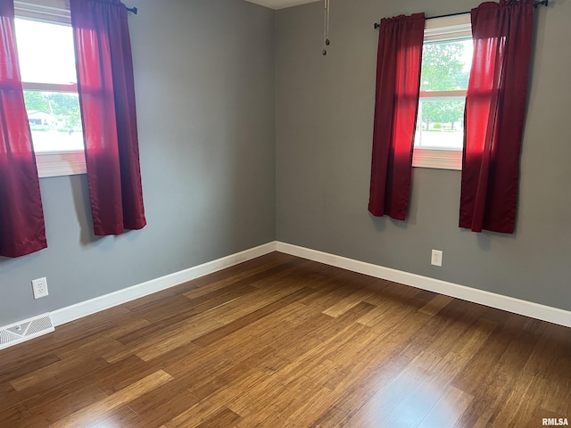 1302 Maple Ave, Macomb, IL 61455 - empty room with baseboards and dark wood-style flooring