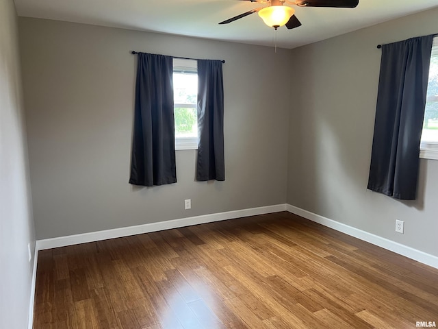 1302 Maple Ave, Macomb, IL 61455 - spare room with a ceiling fan, wood finished floors, and baseboards
