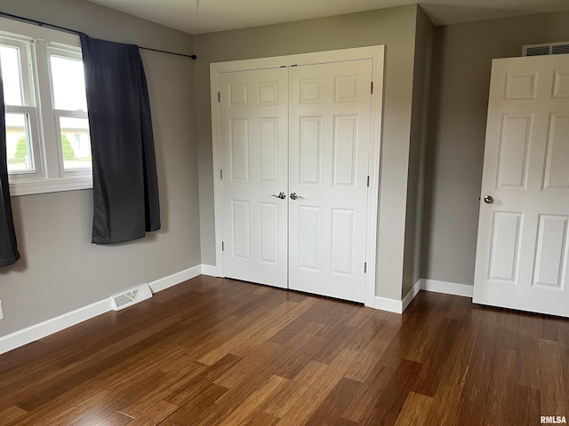 1302 Maple Ave, Macomb, IL 61455 - unfurnished bedroom with a closet, wood finished floors, and baseboards