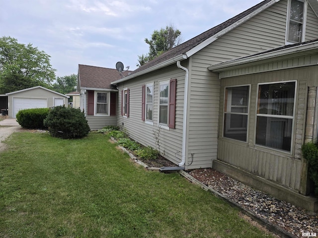504 S Pennsylvania Ave, Abingdon, IL 61510 - view of side of property with an outdoor structure, a lawn, a garage, and a shingled roof