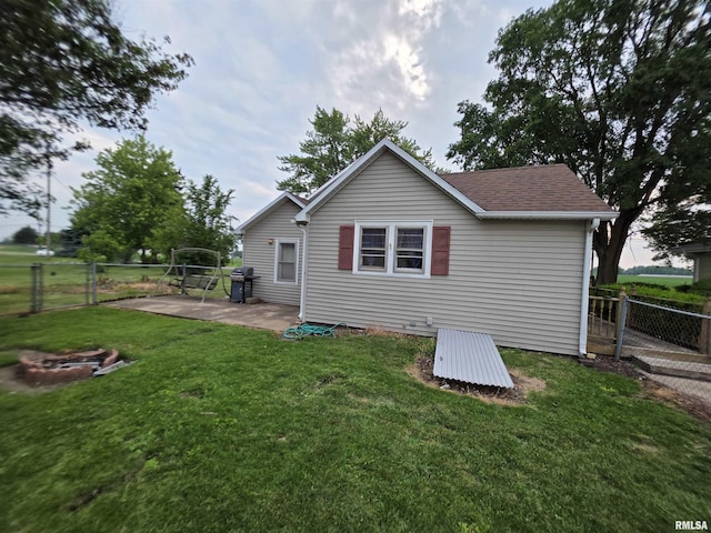 504 S Pennsylvania Ave, Abingdon, IL 61510 - rear view of property with a fire pit, a patio, a fenced backyard, and a shingled roof
