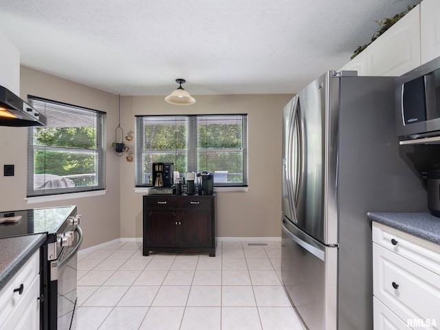 2010 E Paris Ave, Peoria, IL 61614 - kitchen featuring stainless steel appliances, healthy amount of natural light, dark countertops, and white cabinets