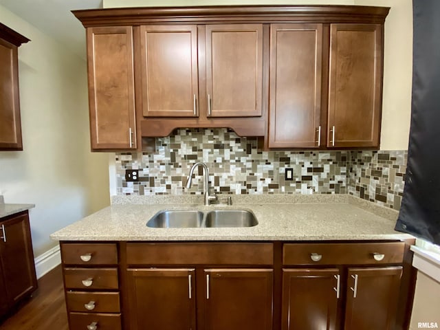 1502 W Columbia Ter, Peoria, IL 61606 - kitchen with a sink, decorative backsplash, light stone countertops, and dark wood-style flooring