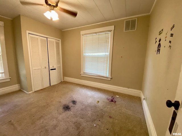 1502 W Columbia Ter, Peoria, IL 61606 - unfurnished bedroom with a closet, multiple windows, and carpet flooring