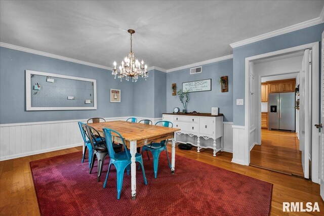 486 E High Point Dr, Peoria, IL 61614 - dining area with wood finished floors, a chandelier, a wainscoted wall, and ornamental molding