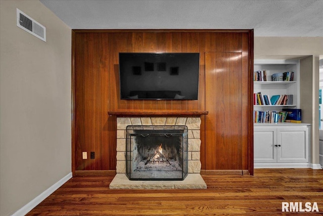 486 E High Point Dr, Peoria, IL 61614 - detailed view of wood finished floors, a stone fireplace, baseboards, and a textured ceiling