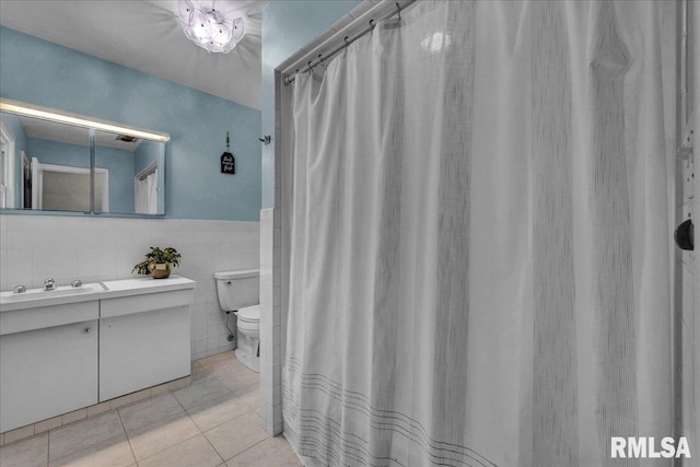 486 E High Point Dr, Peoria, IL 61614 - bathroom featuring toilet, tile patterned flooring, vanity, tile walls, and wainscoting