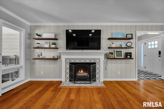 486 E High Point Dr, Peoria, IL 61614 - unfurnished living room with crown molding, baseboards, wood finished floors, a tile fireplace, and wooden walls