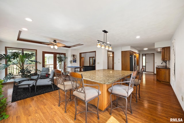 905 Highland Ct, Germantown Hills, IL 61548 - kitchen with wood finished floors, a breakfast bar area, brown cabinets, a sink, and ceiling fan
