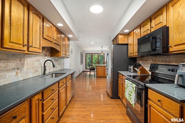 905 Highland Ct, Germantown Hills, IL 61548 - kitchen featuring black appliances, a sink, brown cabinets, light wood-type flooring, and tasteful backsplash