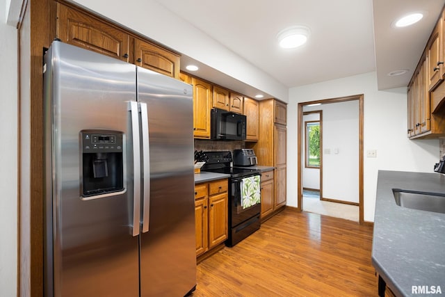 905 Highland Ct, Germantown Hills, IL 61548 - kitchen featuring black appliances, tasteful backsplash, dark countertops, a sink, and light wood finished floors