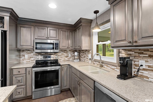 22 Cypress Pt, Pekin, IL 61554 - kitchen with appliances with stainless steel finishes, a sink, decorative backsplash, wood finished floors, and light stone counters