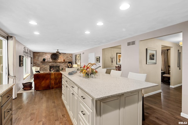 22 Cypress Pt, Pekin, IL 61554 - kitchen with open floor plan, a kitchen breakfast bar, wood finished floors, a kitchen island, and recessed lighting