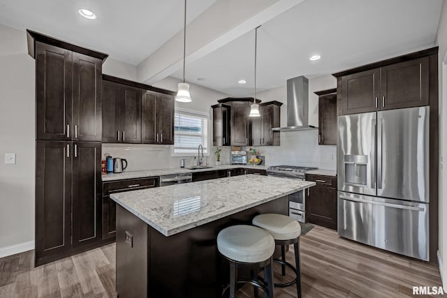 11306 N Joseph St, Dunlap, IL 61525 - kitchen with appliances with stainless steel finishes, wall chimney exhaust hood, dark brown cabinets, a center island, and light wood-style floors
