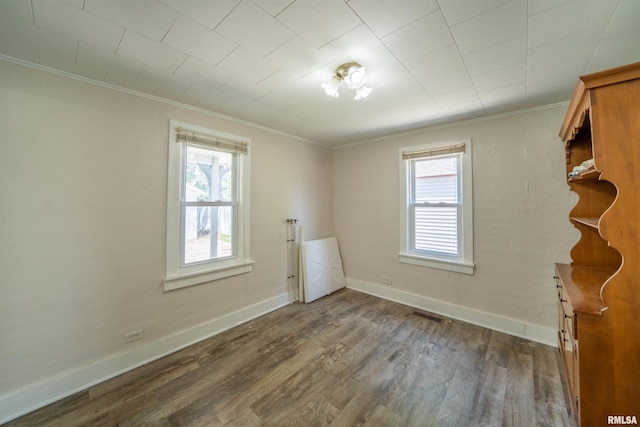 116 S 8th Ave, Canton, IL 61520 - empty room featuring crown molding, healthy amount of natural light, dark wood-type flooring, and baseboards