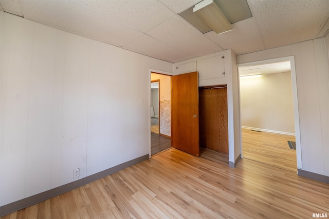 116 S 8th Ave, Canton, IL 61520 - unfurnished bedroom with light wood-style flooring, a drop ceiling, and baseboards