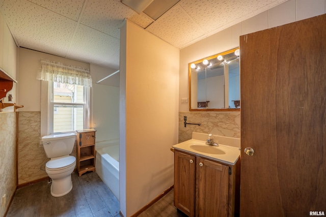 116 S 8th Ave, Canton, IL 61520 - full bath with wood finished floors, vanity, toilet, tile walls, and shower / washtub combination