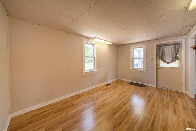 116 S 8th Ave, Canton, IL 61520 - unfurnished room with light wood finished floors, baseboards, and a paneled ceiling