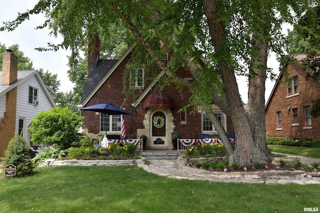 3307 N Biltmore Ave, Peoria, IL 61604 - tudor-style house with a front yard, brick siding, and roof with shingles