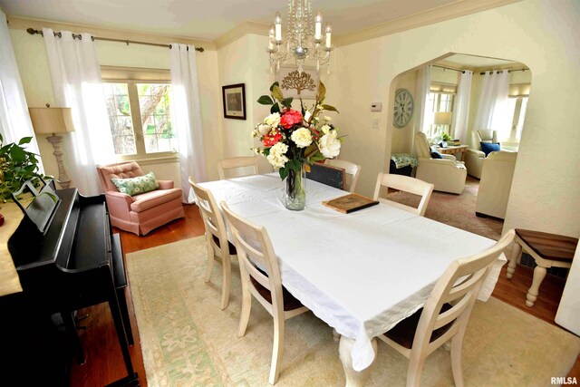 3307 N Biltmore Ave, Peoria, IL 61604 - dining room featuring light wood-style floors, arched walkways, ornamental molding, and a chandelier