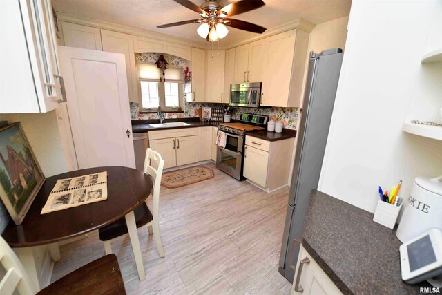 3307 N Biltmore Ave, Peoria, IL 61604 - kitchen featuring appliances with stainless steel finishes, dark countertops, a ceiling fan, and decorative backsplash