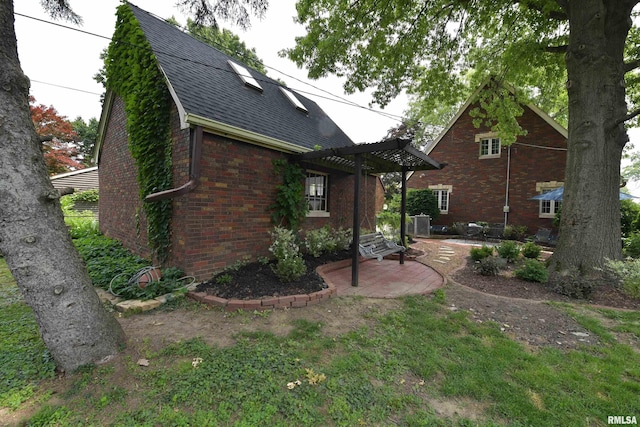 3307 N Biltmore Ave, Peoria, IL 61604 - view of side of property featuring brick siding, roof with shingles, a patio area, and a pergola