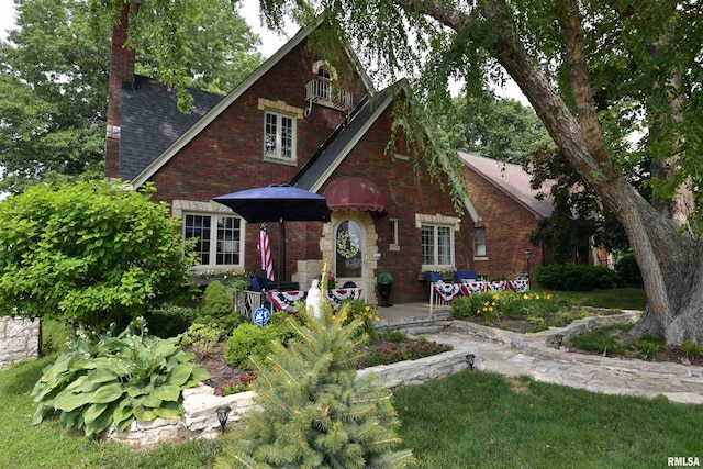 3307 N Biltmore Ave, Peoria, IL 61604 - english style home with a chimney, a shingled roof, and brick siding