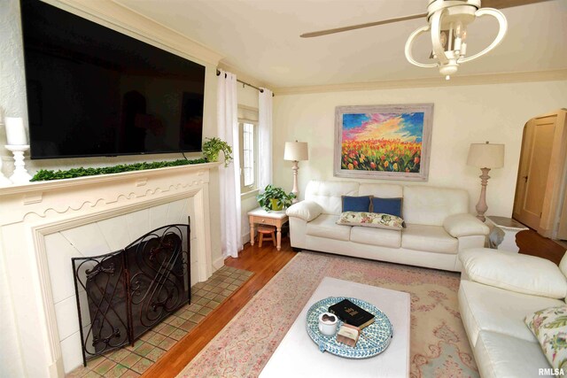 3307 N Biltmore Ave, Peoria, IL 61604 - living room featuring a ceiling fan, light wood-type flooring, a fireplace, and crown molding