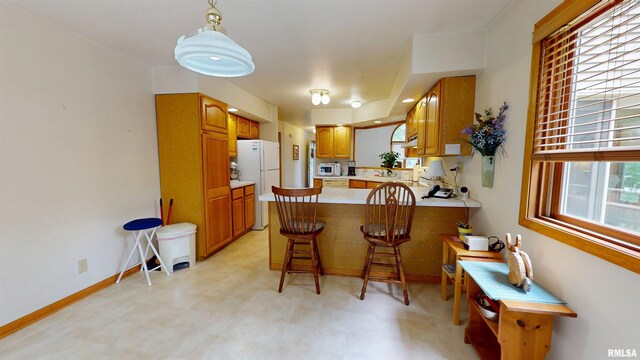 1111 Windy Hill Ct, Varna, IL 61375 - kitchen with white appliances, light flooring, a peninsula, light countertops, and brown cabinets