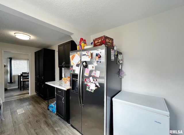1520 N Finney St, Chillicothe, IL 61523 - kitchen featuring stainless steel fridge, refrigerator, wood finished floors, dark cabinetry, and a textured ceiling
