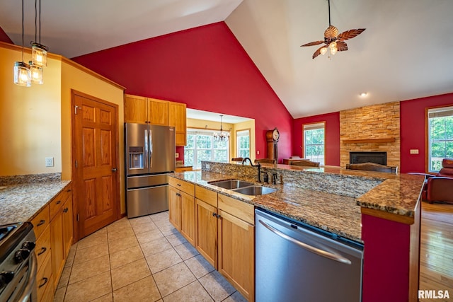4627 S Queen Aleta Ct, Mapleton, IL 61547 - kitchen with stainless steel appliances, a sink, a stone fireplace, ceiling fan, and open floor plan