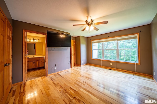 4627 S Queen Aleta Ct, Mapleton, IL 61547 - unfurnished bedroom featuring light wood-style floors, connected bathroom, a ceiling fan, and a closet
