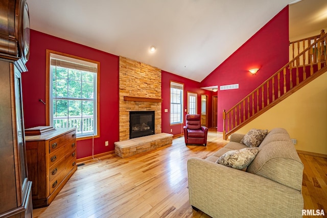 4627 S Queen Aleta Ct, Mapleton, IL 61547 - living room with vaulted ceiling, stairway, a stone fireplace, and light wood-style floors