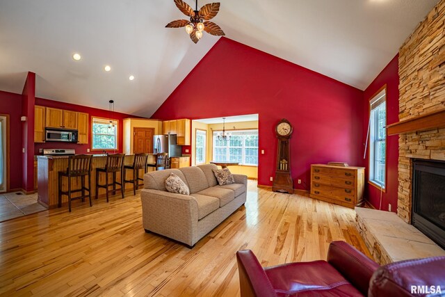 4627 S Queen Aleta Ct, Mapleton, IL 61547 - living room with light wood-style flooring, a stone fireplace, high vaulted ceiling, a ceiling fan, and recessed lighting